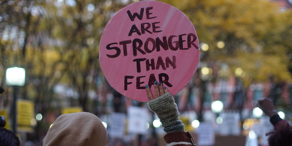 A woman holds a protest sign